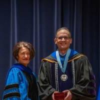 Provost Mili and man take picture on stage